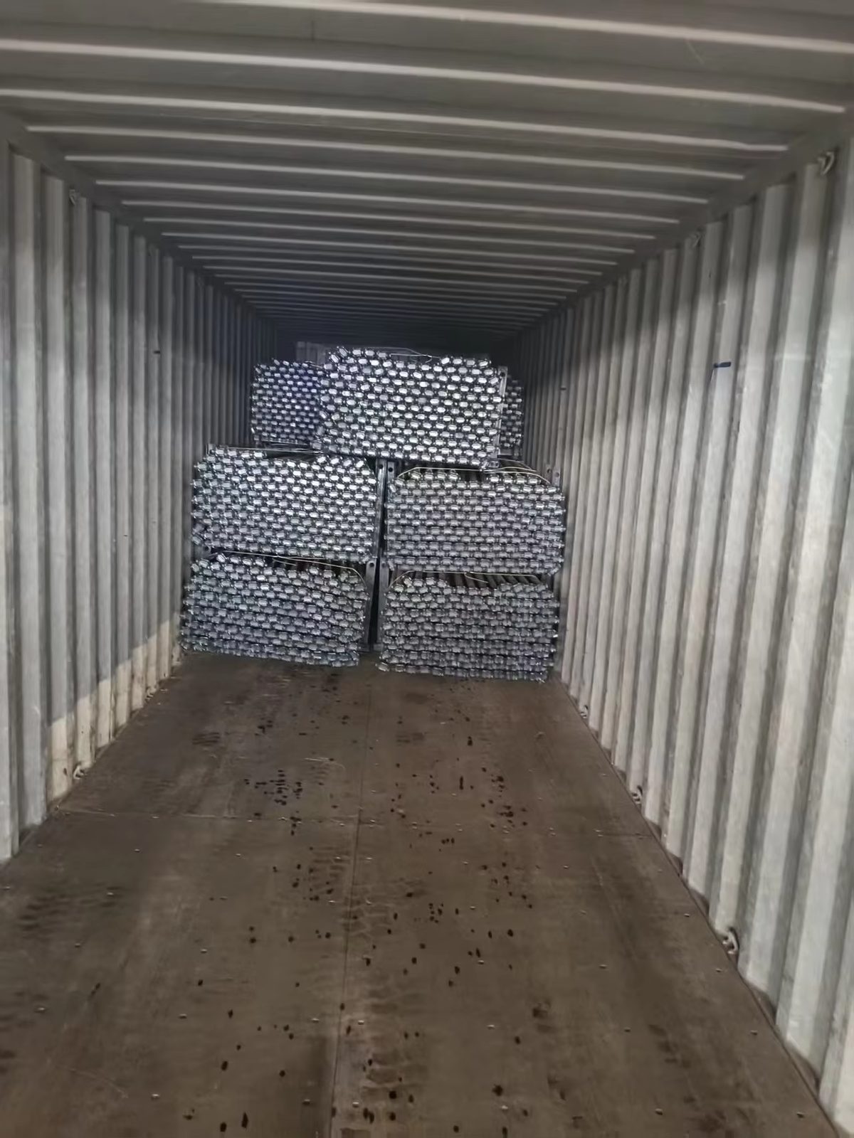 Steel coils loaded in 20GP container with timber chocks, steel wire lashing and floor dunnage